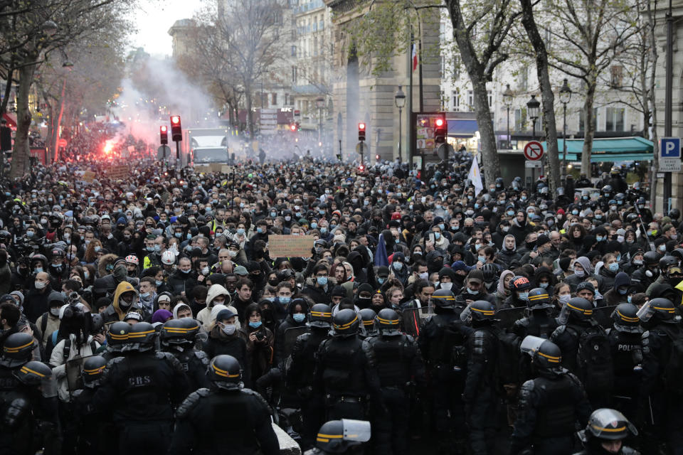 Demonstrators are blocked by police officers during a protest against a proposed bill , Saturday, Dec.12, 2020 in Paris. The bill's most contested measure could make it more difficult for people to film police officers. It aims to outlaw the publication of images with intent to cause harm to police. The provision has caused such an uproar that the government has decided to rewrite it. Critics fear the law could erode press freedom and make it more difficult to expose police brutality. (AP Photo/Lewis Joly)