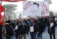 Protesters hold a banner depicting the puppet Pinocchio with the face of Italian Prime Minister Matteo Renzi and reading "Renzi pay attention to the clause 18" during a demonstration against government in downtown Rome December 12, 2014. REUTERS/Remo Casilli