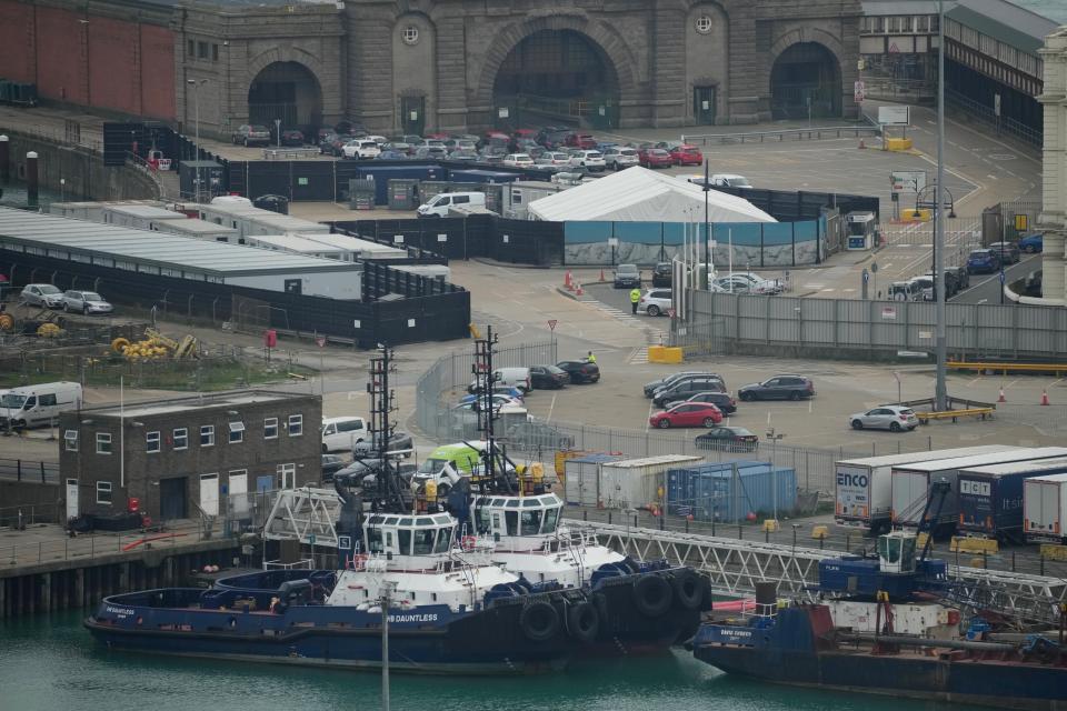 Security guards stand in front of the gate near the migrant processing centre in Dover, England, Monday, Oct. 31, 2022. An attacker threw firebombs an immigration center in the English port town of Dover on Sunday before killing himself, officials said. One other person was lightly injured. The Kent Police force said "two to three incendiary devices" were thrown at the facility where recently arrived migrants are taken, and "one minor injury has been reported." (AP Photo/Kin Cheung)