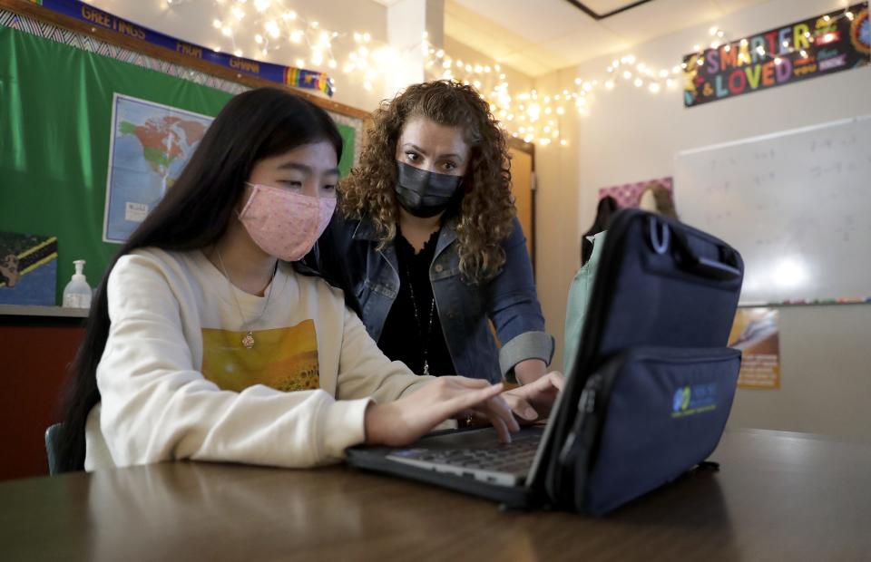 Resource teacher Tara Koji works with Youa Lor during a class at Oshkosh North High School.