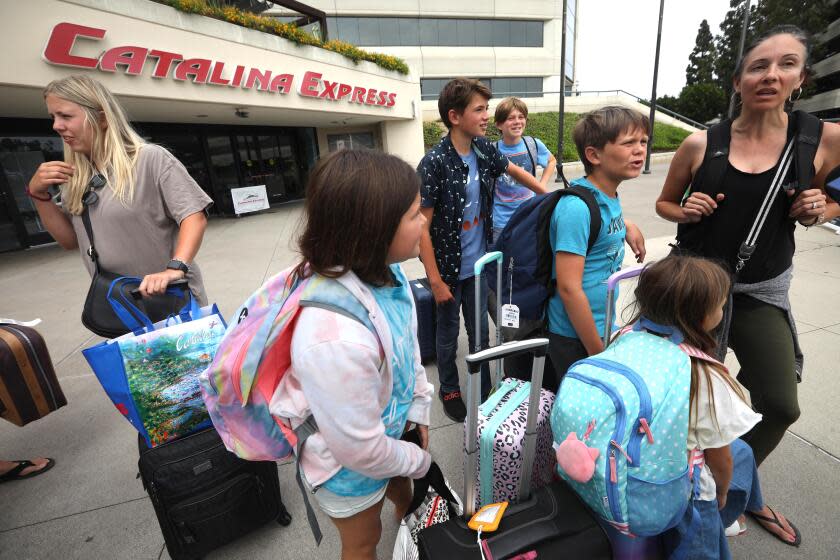 LONG BEACH, CA - AUGUST 19, 2023 - Gina McMullen, right, from Oceanside, stands with members of her family right, stands next to members after having to evacuate from Catalina Island due to Hurricane Hilary in Long Beach on August 19, 2023. They've been on the island since Thursday. (Genaro Molina / Los Angeles Times)