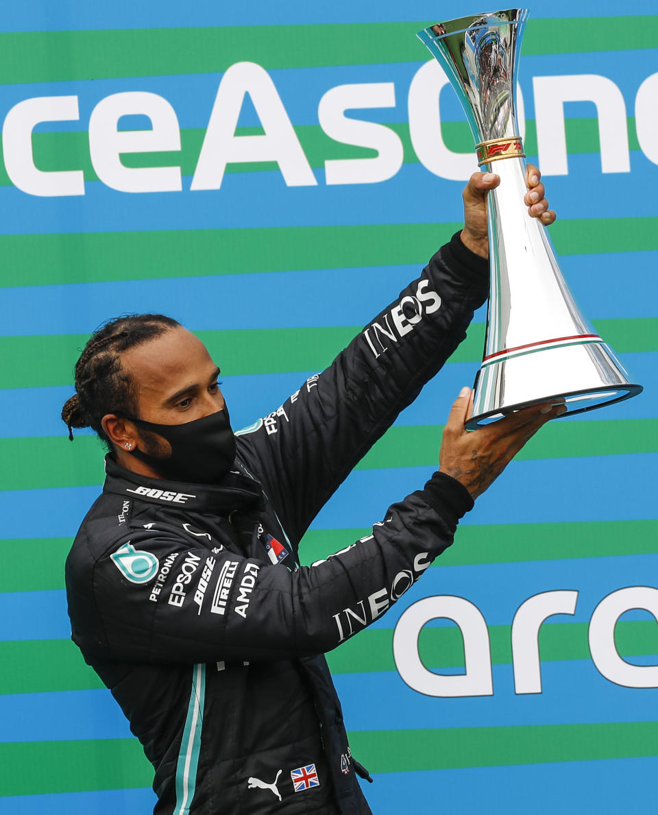 Mercedes' British driver Lewis Hamilton celebrates with the trophy on the podium of the Formula One Hungarian Grand Prix race at the Hungaroring circuit in Mogyorod near Budapest, Hungary, on July 19, 2020. (Photo by Leonhard Foeger / POOL / AFP) (Photo by LEONHARD FOEGER/POOL/AFP via Getty Images)