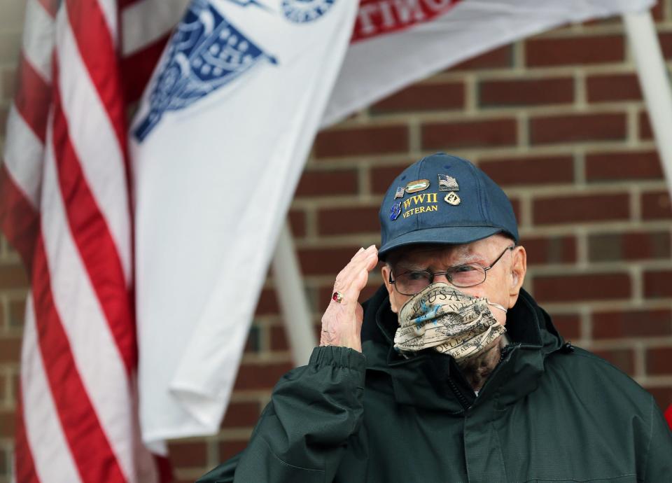 World War II veteran Ray Goulet salutes the crowd who gathered to celebrate his 98th birthday outside Margeson Apartments Thursday, Jan.14, 2021. Goulet was among the first wave of soldiers to storm Omaha Beach in Normandy, France, on D-Day in 1944.