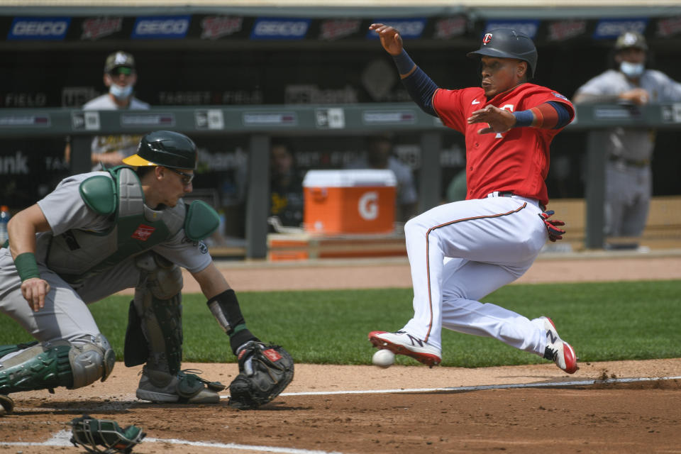 Minnesota Twins Jorge Polanco, right, slides past Oakland Athletics catcher Sean Murphy to score during the third inning of a baseball game, Sunday, May 16, 2021, in Minneapolis. Originally called out by home plate umpire John Libka, Polanco was called safe after review. (AP Photo/Craig Lassig)