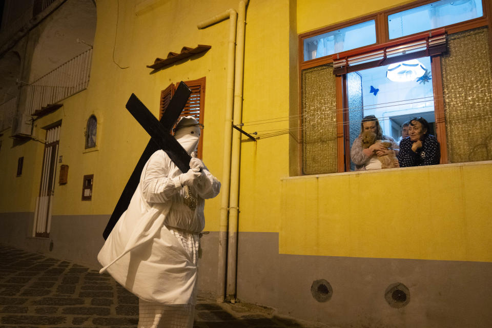 A member of a confraternity carries a cross during a Holy Thursday procession the in Procida Island, Italy, Thursday, March 28, 2024. Italy is known for the religious processions that take over towns big and small when Catholic feast days are celebrated throughout the year. But even in a country where public displays of popular piety are a centuries-old tradition, Procida's Holy Week commemorations stand out. (AP Photo/Alessandra Tarantino)
