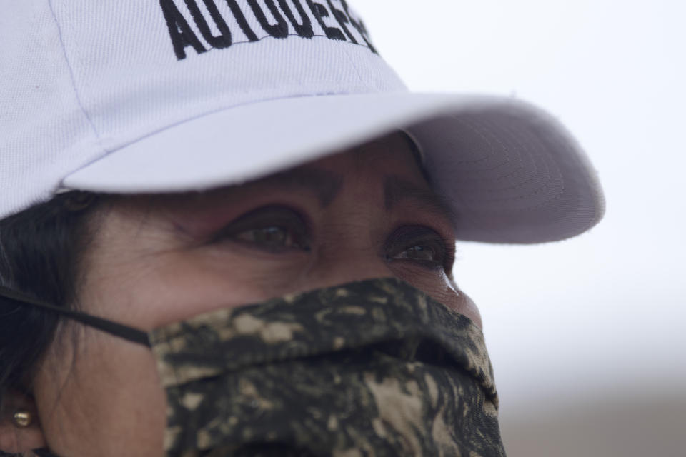 A woman who says she is part of a female-led, self-defense group explains that her son was disappeared, during an interview at the check-point set up by her group of armed women to protect the entrance of El Terrero in Michoacan state, Mexico, Wednesday, Jan. 13, 2021. Many of the women vigilantes in the hamlet of El Terrero have lost sons, brothers or fathers in the bloody incursion into the state of Michoacán by the Jalisco cartel. (AP Photo/Armando Solis)