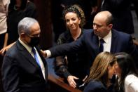 Head of Oposition Benjamin Netanyahu and Israel Prime Minister Naftali Bennett gesture following the vote on the new coalition at the Knesset, Israel's parliament, in Jerusalem