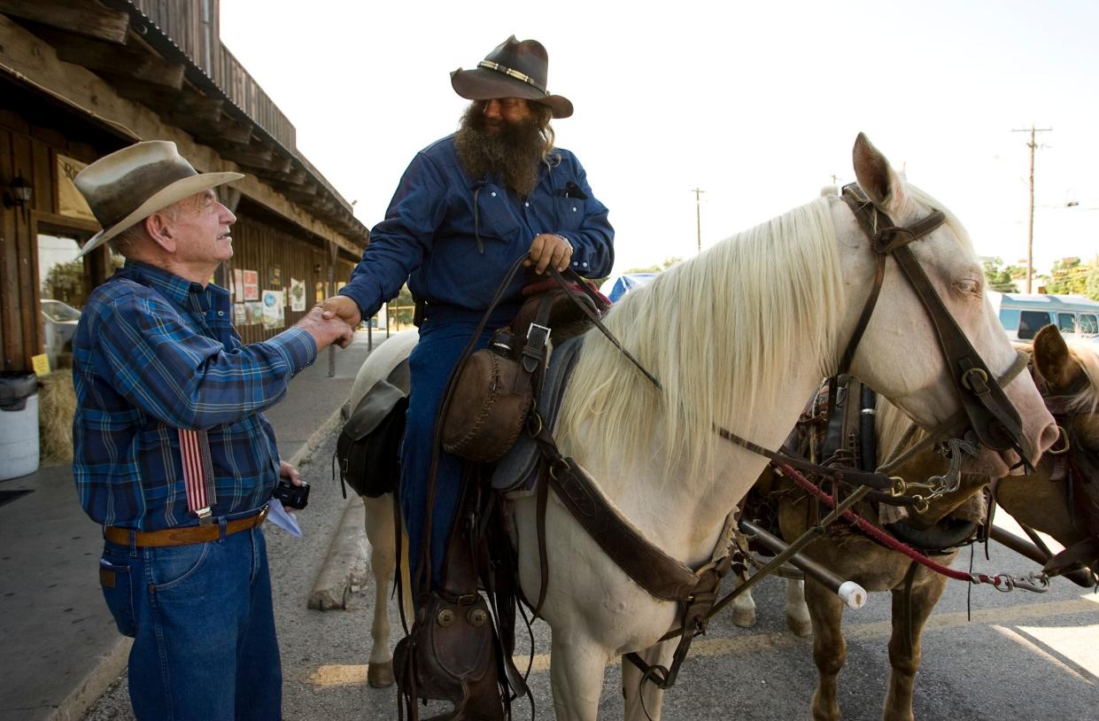 In 2010, Murray Callahan, left, says goodbye to Ernest Nunley, who took a horseback ride across the country. They were in front of Callahan's General Store, where Murray worked with his family for decades. He died March 25.