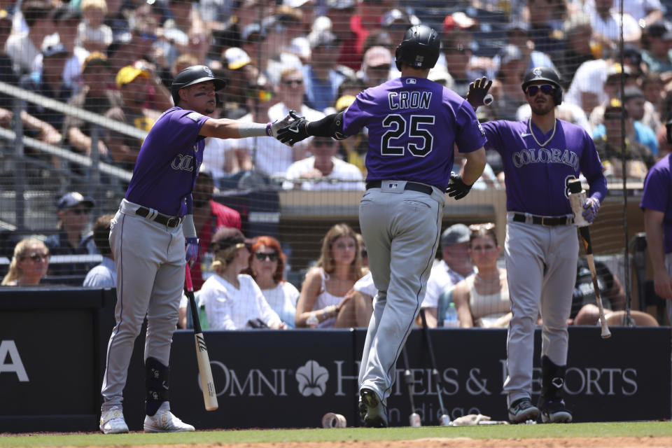 Colorado Rockies' C.J. Cron, center, is congratulated by Yonathan Daza, left, and Joshua Fuentes, right, after hitting a solo home run against the San Diego Padres in the fourth inning of a baseball game Sunday, July 11, 2021, in San Diego. (AP Photo/Derrick Tuskan)