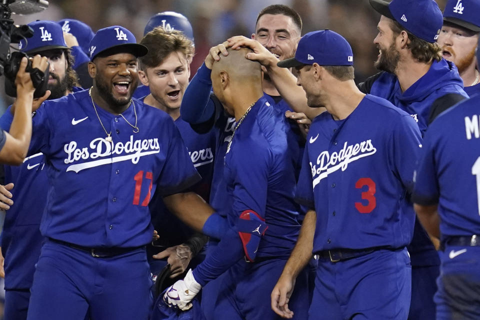 Los Angeles Dodgers' Mookie Betts, center, is greeted by teammates after he hit a walk-off single to win a baseball game 3-2 against the Arizona Diamondbacks in Los Angeles, Thursday, Sept. 22, 2022. Freddie Freeman scored. (AP Photo/Ashley Landis)