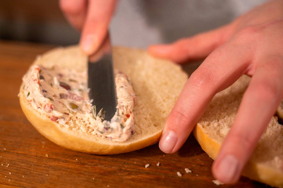 Brittany Erwin, owner of B’s Bagels and Butters in Gig Harbor, spreads a Giardiniera Cream cheese schmear onto a bagel.