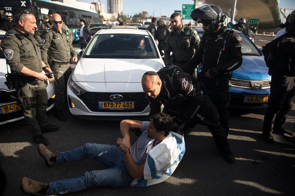 Israeli police officers remove a protester blocking a main road (Getty Images)