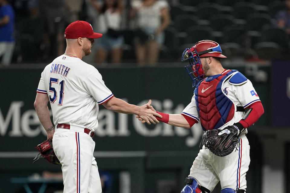 Texas Rangers' Will Smith and Mitch Garver, right, shake hands after the team's 6-4 win in a baseball game against the St. Louis Cardinals, Tuesday, June 6, 2023, in Arlington, Texas. (AP Photo/Tony Gutierrez)