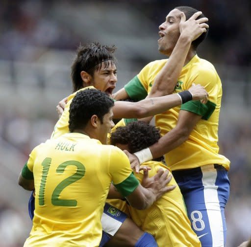 El brasileño Leandro Damiao (tapado) celebra con sus compañeros Hulk (I), Neymar (2do. I) y Rómulo (D) el tercer gol de su equipo ante Honduras, en partido porlos cuartos de final del torneo olímpico de fútbol disputado el 04 de agosto de 2012 em Newcastle. (AFP | graham stuart)