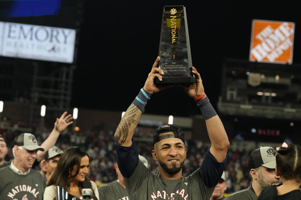 Atlanta Braves' Eddie Rosario holds the Most Valuable Player Trophy after winning Game 6 of baseball's National League Championship Series against the Los Angeles Dodgers Sunday, Oct. 24, 2021, in Atlanta. The Braves defeated the Dodgers 4-2 to win the series. (AP Photo/Brynn Anderson)