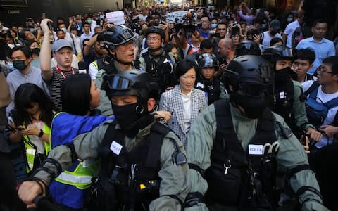 Prominent pro-Beijing law maker Regina Ip is escorted by police while surrounded by pro-democracy protesters - Credit: FAZRY ISMAIL/EPA-EFE/REX