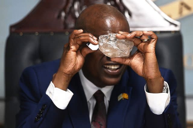 <p>Monirul Bhuiyan/AFP/Getty</p> Botswana's President Mokgweetsi Masisi looks at a large diamond discovered in Botswana at his office in Gaborone on August 22, 2024