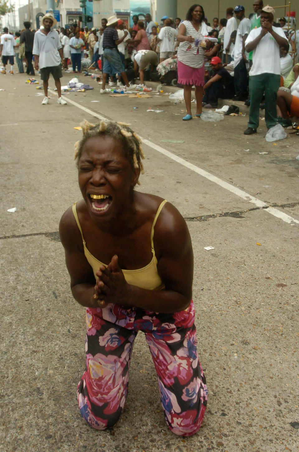 Angela Perkins drops to her knees asking for help among thousands of people gathered at the New Orleans Convention Center waiting in the aftermath of Hurricane Katrina on Sept. 1, 2005<span class="copyright">Melissa Phillip—Houston Chronicle/AP</span>
