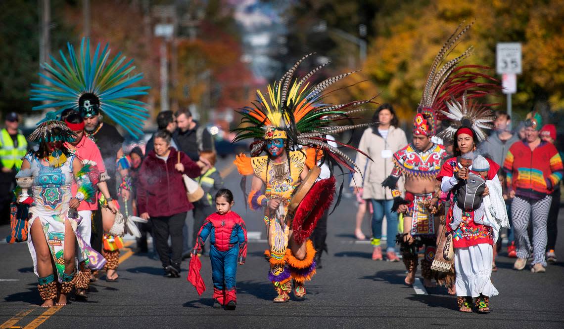 Victor Maldonado (center) leads dancers as they march south on Portland Avenue to the Dia de los Muertos celebration at the Eastside Community Center in Tacoma, Washington, on Saturday, Oct. 29, 2022.