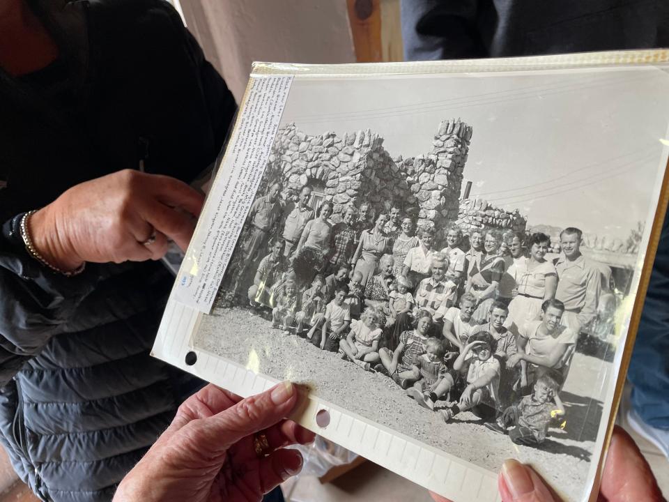 Marjorie Snell of the Desert Hot Springs Historical Society holds a family photograph of Lee and Leonora Watkins, center of middle row, with their relatives in front of the Historic Rock House that Lee built.