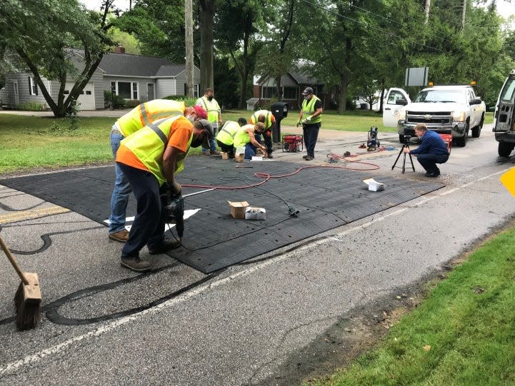 Akron city workers install a speed table in the summer of 2020 on Schocalog Road, one of two locations used to pilot the portable speed-reduction tool that acts like a more gentle speed bump.