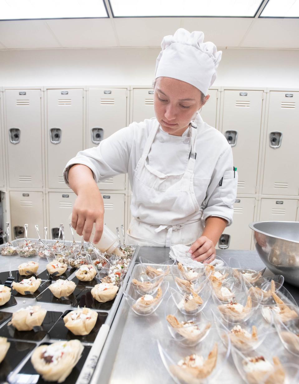 Sarah Rudd prepares Greek quinoa salad for the Garde Manger donor appreciation reception in the Molly McGuire School of Culinary Arts and Hospitality Programs at Pensacola State College in Pensacola on Wednesday, July 19, 2023.