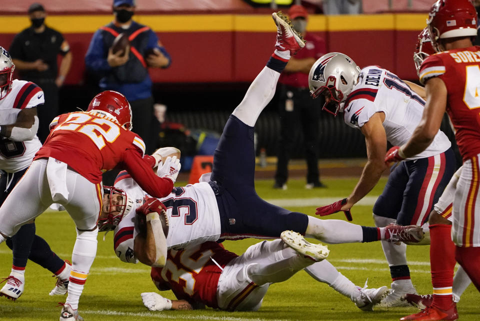 New England Patriots running back Rex Burkhead (34) is tackled by Kansas City Chiefs safety Tyrann Mathieu, bottom, and safety Juan Thornhill (22) during the second half of an NFL football game, Monday, Oct. 5, 2020, in Kansas City. (AP Photo/Jeff Roberson)