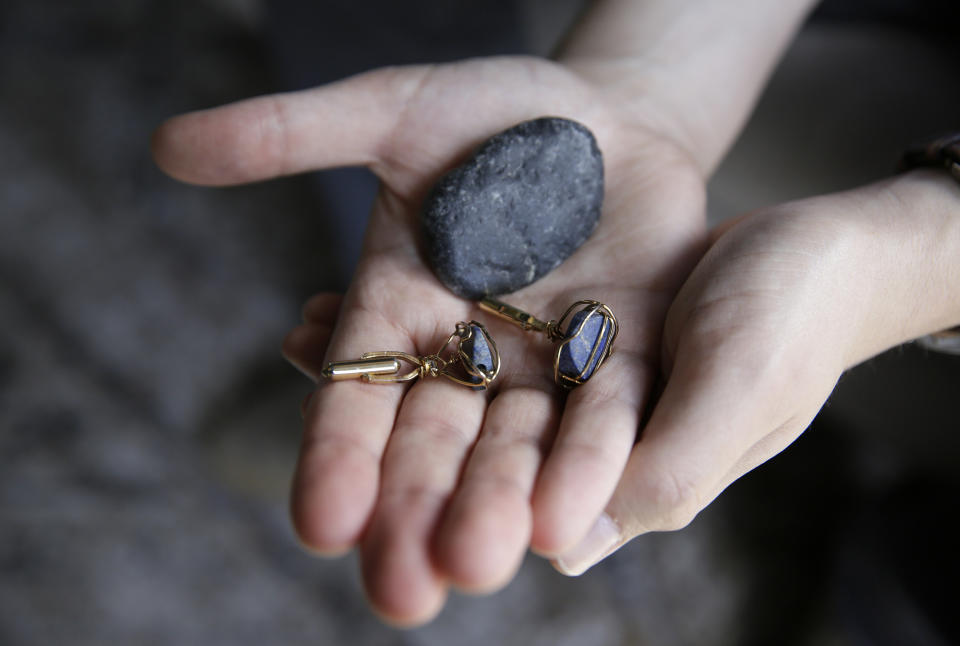 Dane Shikman holds a rock from the beach where the ashes of his mother, Elizabeth Gaunt, were scattered in Ireland along with a pair of cufflinks she had made for him as he sits at his home in San Francisco on Friday, April 19, 2019. His mother, who had a history of mental health and substance abuse problems, killed herself at the Lake County, Calif, jail in 2015, after she repeatedly cried for help. Her son's wrongful death lawsuit resulted in a $2 million settlement. (AP Photo/Eric Risberg)