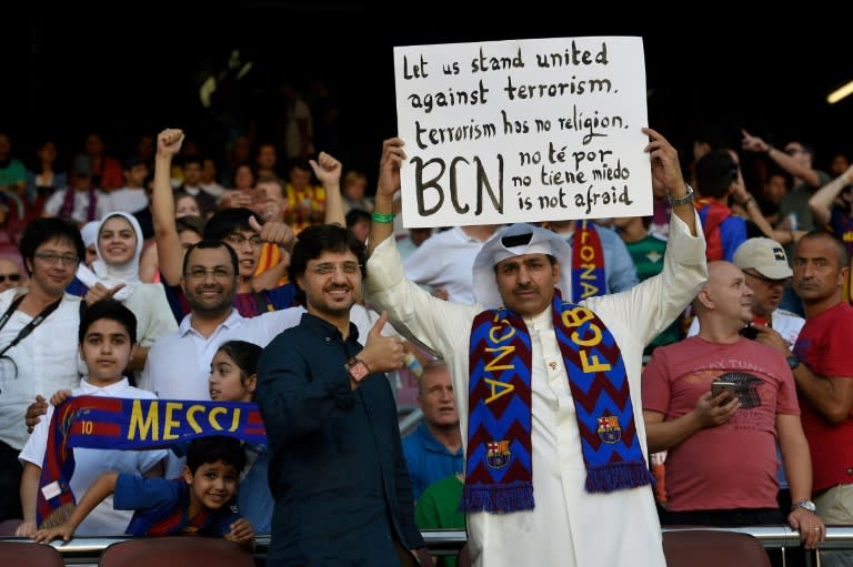 A Barcelona fan holds a placard with slogans against terrorism at the Camp Nou stadium in Barcelona on August 20, 2017