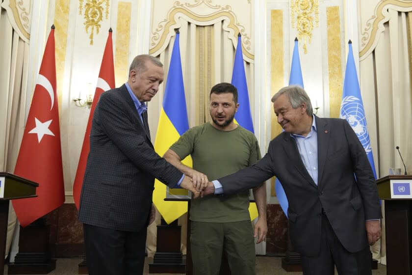 El presidente ucraniano Volodymyr Zelenskyy (centro), su homólogo tuco Recep Tayyip Erdogan (izquierda), y el secretario general de la ONU Antonio Guterres estrechan las manos tras sostener una reunión en Leópolis, Ucrania, el jueves 18 de agosto de 2022. (AP Foto/Evgeniy Maloletka)