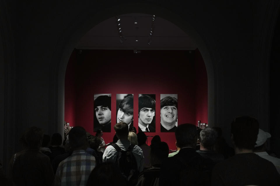 Visitors look at pictures during a preview of Paul McCartney Photographs 1963-64: Eyes of the Storm exhibition at the National Portrait Gallery in London, Britain, Tuesday, June 27, 2023. The exhibition consists of unseen photographs taken by Paul McCartney from the Beatles at the height of Beatlemania. The gallery will open it's doors from June 28, 2023 until October 1, 2023. (AP Photo/Frank Augstein)