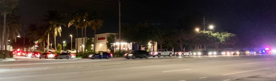 Cars wind through the Raising Cane's drive-thru parking lot and out onto Boynton Beach Boulevard Tuesday night during the fast food restaurant's grand opening.