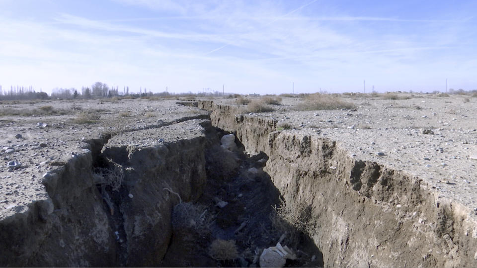 This frame grab from video taken on Jan. 8, 2019, shows fissure in the land caused by drought and excessive water pumping, in Malard, west of Tehran, Iran. Fissures appear along roads, while massive holes open up in the countryside, their gaping maws a visible sign from the air of something Iranian authorities now openly acknowledge: The area around the capital Tehran is literally sinking. (AP Photo)