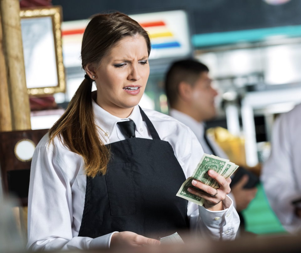 waitress angrily looking at a small tip