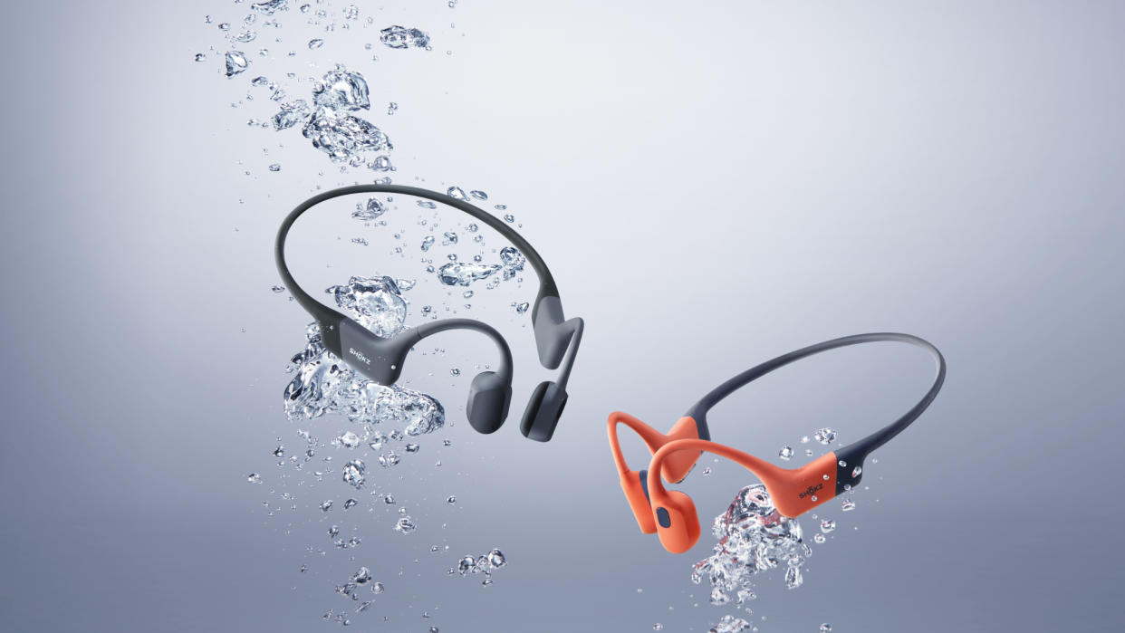  Shokz OpenSwim Pro - one in grey, one in red - in an underwater press pic. 