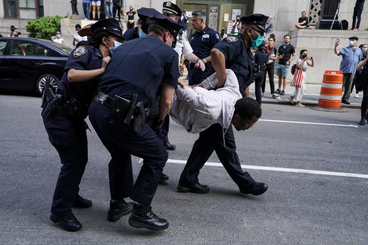 <span>Police officers arrest a protester in New York on 29 May 2020.</span><span>Photograph: Timothy A Clary/AFP via Getty Images</span>