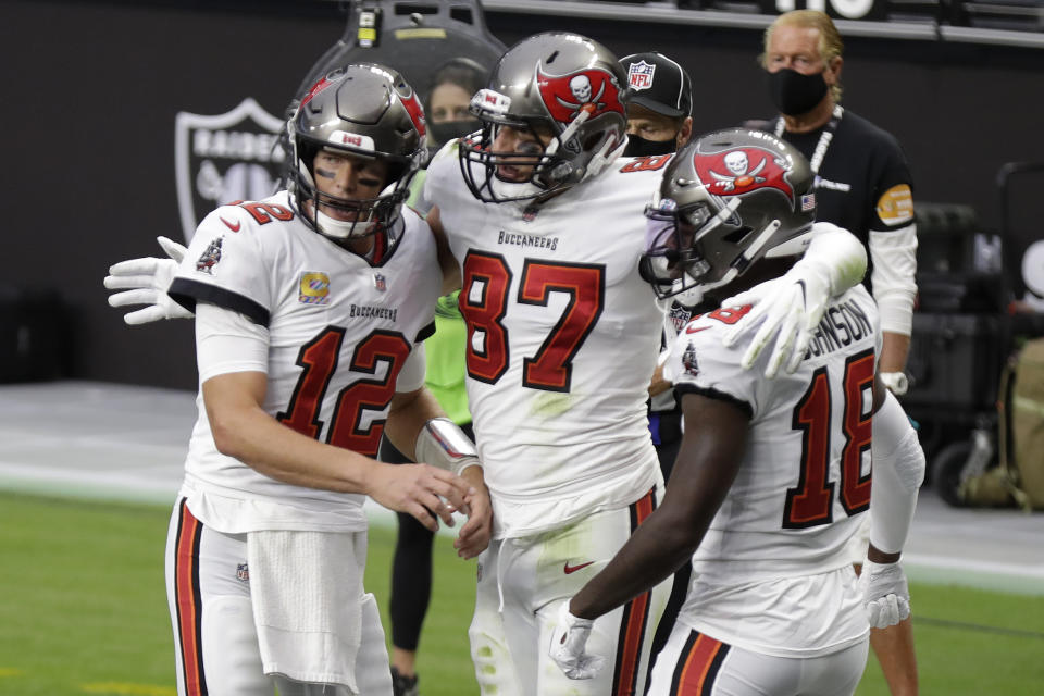 Tampa Bay Buccaneers quarterback Tom Brady (12) celebrates with tight end Rob Gronkowski (87) and wide receiver Tyler Johnson (18) after Gronkowski scored a touchdown against the Las Vegas Raiders during the first half of an NFL football game, Sunday, Oct. 25, 2020, in Las Vegas. (AP Photo/Isaac Brekken)