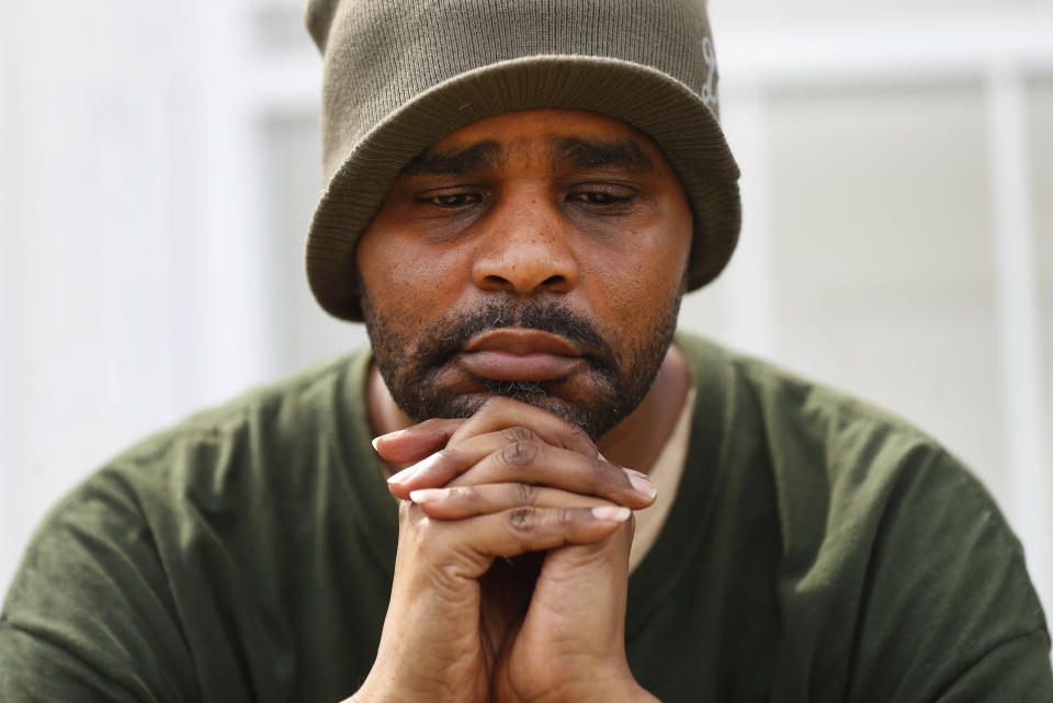 Jamon Jordan sits outside of his home in Detroit, Friday, April 24, 2020. Jordan could not mourn his mother, Jacquelynne Jordan, in the traditional way. At Jacquelynne Jordan's memorial in early April, there were just seven people. No hugs. No traditional dinner where family members could gather to honor the 66-year-old matriarch's memory after she died from the new coronavirus. (AP Photo/Paul Sancya)