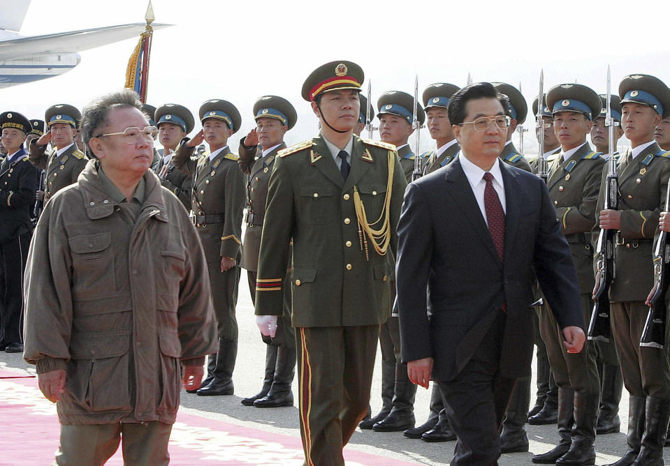 FILE - In this Oct. 28, 2005, file photo released by China's Xinhua News Agency, then Chinese President Hu Jintao, front right, and then North Korean leader Kim Jong Il, front left, inspect an honor guard as Hu arrives at the airport in Pyongyang, North Korea. As North Korea celebrates the 70th anniversary of its founding on Sunday, Sept. 9, 2018, the presence - or absence - of Xi could highlight just how much vitality has been restored to ties between Pyongyang and its most powerful backer after a prolonged chill. (Ju Peng/Xinhua via AP, File)