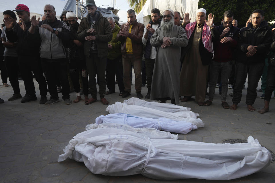 Palestinians pray over the bodies of a woman and her four children killed in the Israeli bombardments of the Gaza Strip at Al Aqsa Hospital in Deir al Balah on Tuesday, Feb. 20, 2024. (AP Photo/Adel Hana)