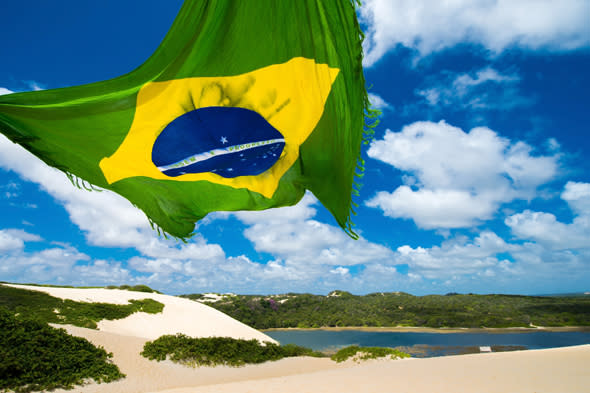 NATAL, BRAZIL - NOVEMBER 14:  View of Genipabu  lagoon with a Brazilian flag on November 14, 2013 in Natal, Brazil. The Ecological Tourist Park Dunes Genipabu includes a beach, a large complex of dunes, a lagoon and a protected area (Photo by Buda Mendes/Getty Images)