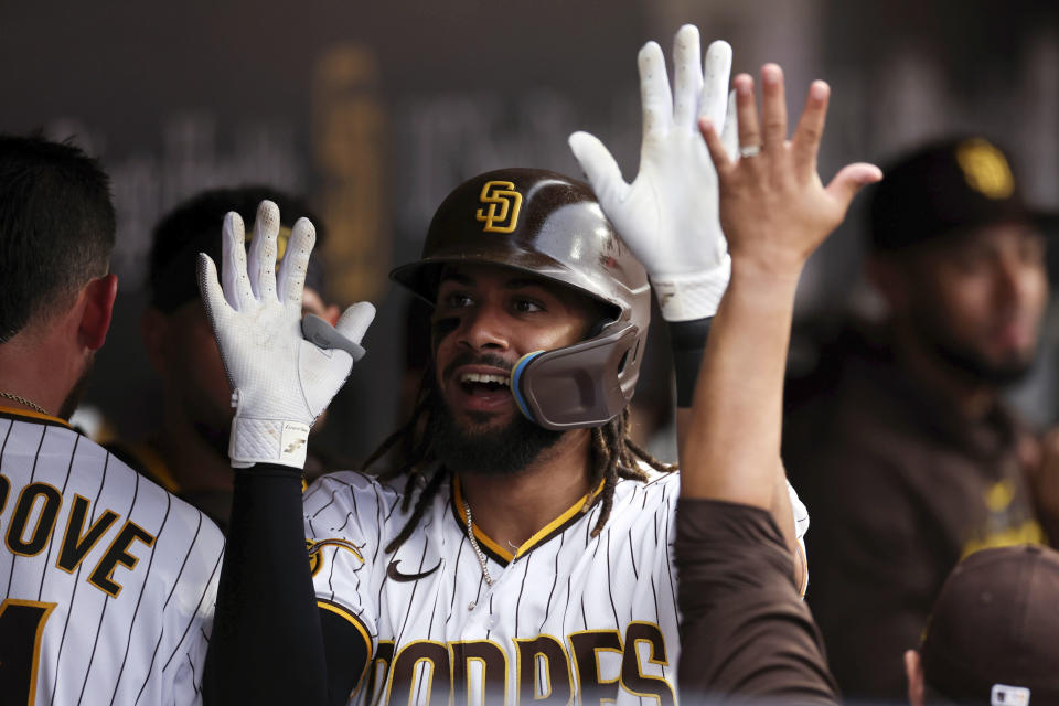 San Diego Padres' Fernando Tatis Jr. is congratulated by teammates in the dugout after hitting a solo home run against the Cleveland Guardians in the second inning of a baseball game Tuesday, June 13, 2023, in San Diego. (AP Photo/Derrick Tuskan)