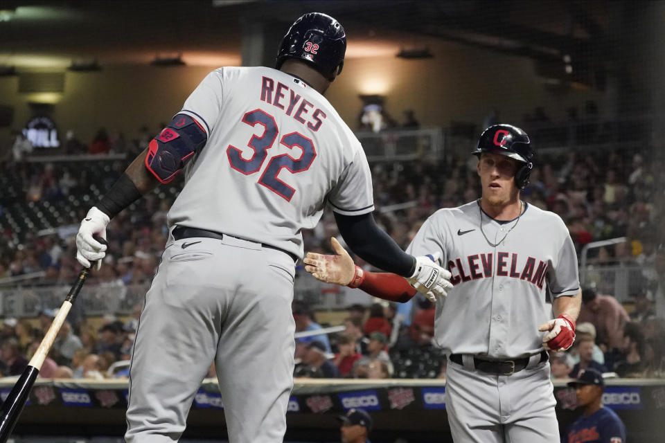 Cleveland Indians' Myles Straw right is congratulated by Franmil Reyes after scoring on a sacrifice fly by Jose Ramirez during the fifth inning of the team's baseball game against the Minnesota Twins on Wednesday, Sept. 15, 2021, in Minneapolis. (AP Photo/Jim Mone)