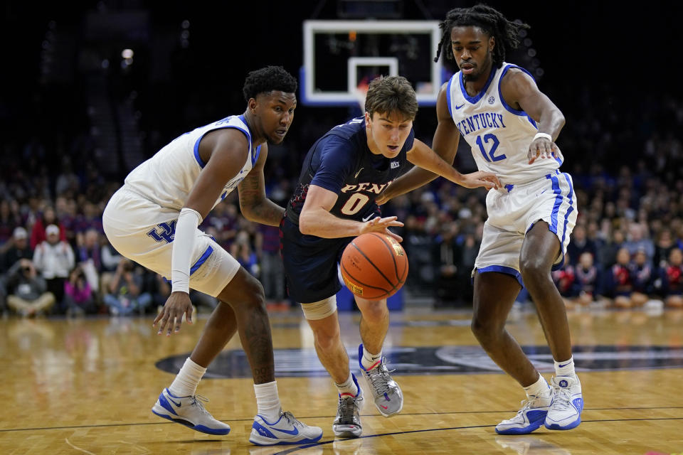 Pennsylvania's Clark Slajchert, center, tries to get past Kentucky's Justin Edwards, left, and Antonio Reeves during the first half of an NCAA college basketball game, Saturday, Dec. 9, 2023, in Philadelphia. (AP Photo/Matt Slocum)