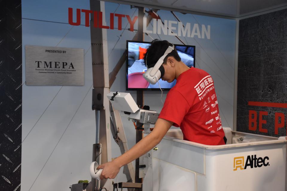 A Gallatin High School student explores a career as a utility lineman, using a virtual reality headset and a simulator.