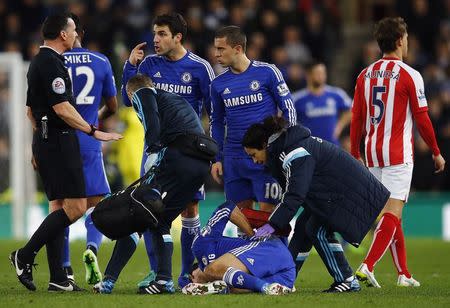 Chelsea's Cesc Fabregas (3rd L) speaks to the referee Neil Swarbrick (L) as Diego Costa receives treatment on the ground during their English Premier League soccer match against Stoke City at the Britannia Stadium in Stoke-on-Trent, northern England December 22, 2014. REUTERS/Darren Staples