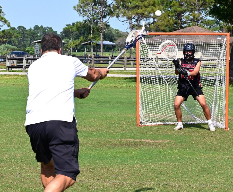 Palm Beach Central coach William Bauer fires a ball toward his goaltender during practice at Okeeheelee on April 4, 2024.
