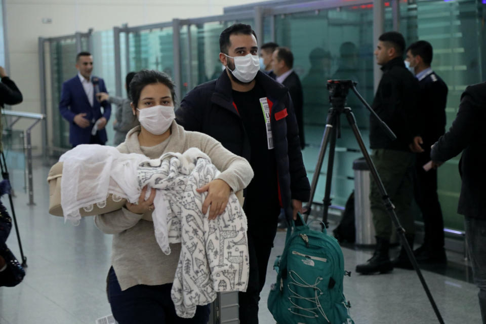 Iraqi migrants arrive to the airport in Irbil, Iraq, early Friday, Nov. 26, 2021. 170 Iraqi nationals returned home Friday from Belarus in a repatriation process that came after tensions at Poland's eastern border, where thousands of migrants became stuck in a cold and soggy forest. (AP Photo/Hussein Ibrahim)