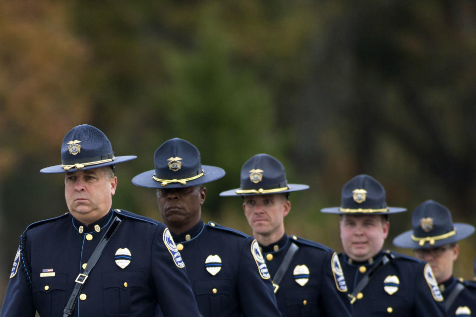 Gwinnett Police officers arrive at the Georgia Southwestern State University Storm Dome before a funeral service for Americus Police Officer Nicholas Smarr, Sunday, Dec. 11, 2016, in Americus, Ga. Smarr and his lifelong friend, Georgia Southwestern State University campus police officer Jody Smith, were killed responding to a domestic violence call on Wednesday. (AP Photo/Branden Camp)