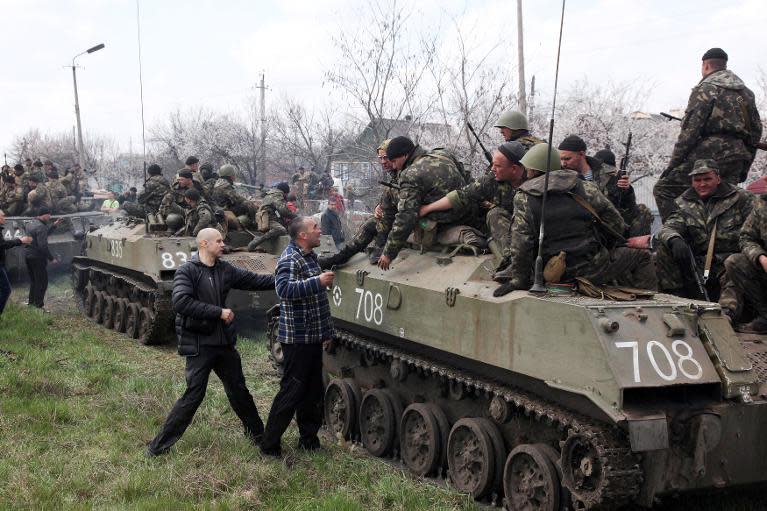 Pro-Russian activists block a collumn of Ukrainian men riding on armoured vehicles in the eastern city of Kramatorsk, on April 16, 2014